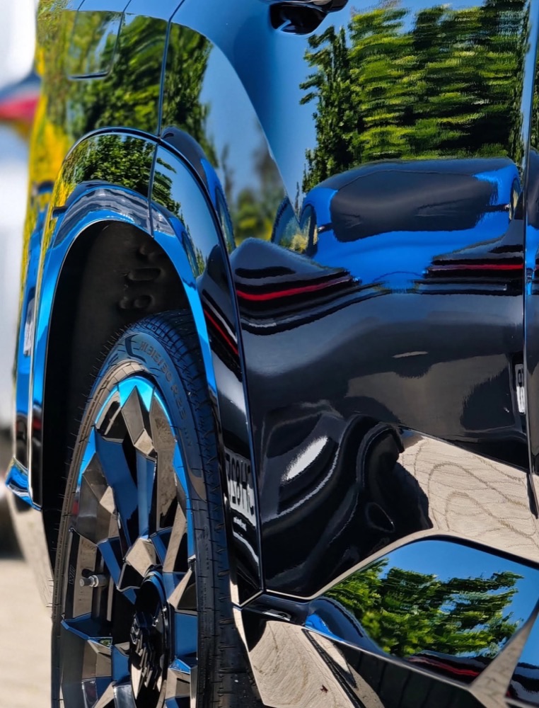 Reflexos perfeitos na pintura escura de um BMW XM, após correção e proteção.