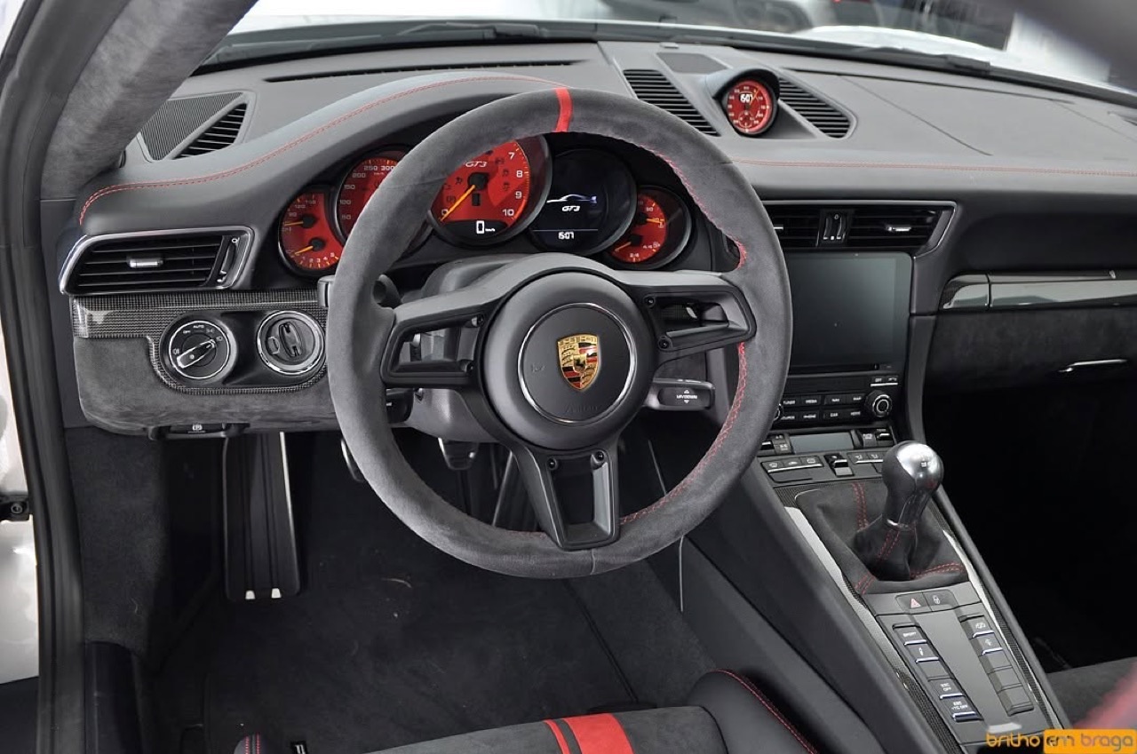 Interior de Porsche 911 GT3 detalhado — volante e consola impecáveis.